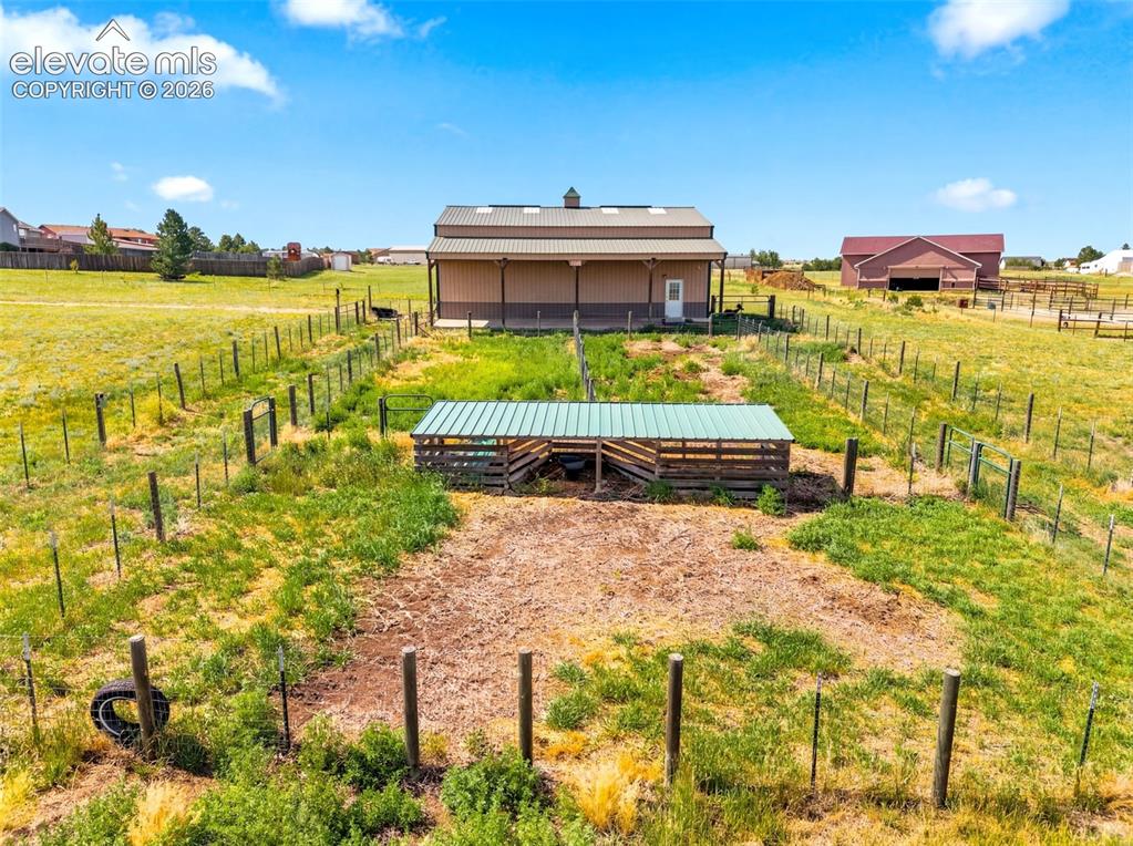 Image 40 of 44: Expansive rural property featuring multiple fenced pastures, a substantial 