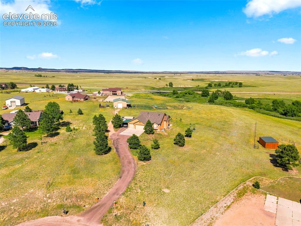 Image 42 of 44: Expansive rural property featuring a main residence, detached garage, and a