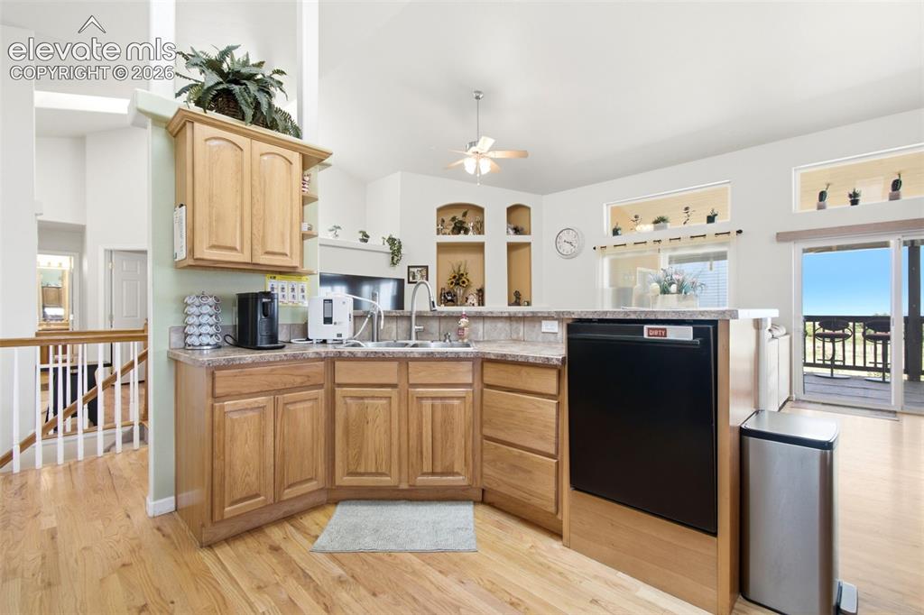 Image 7 of 44: Bright, open kitchen featuring warm wood cabinetry, stainless steel applian