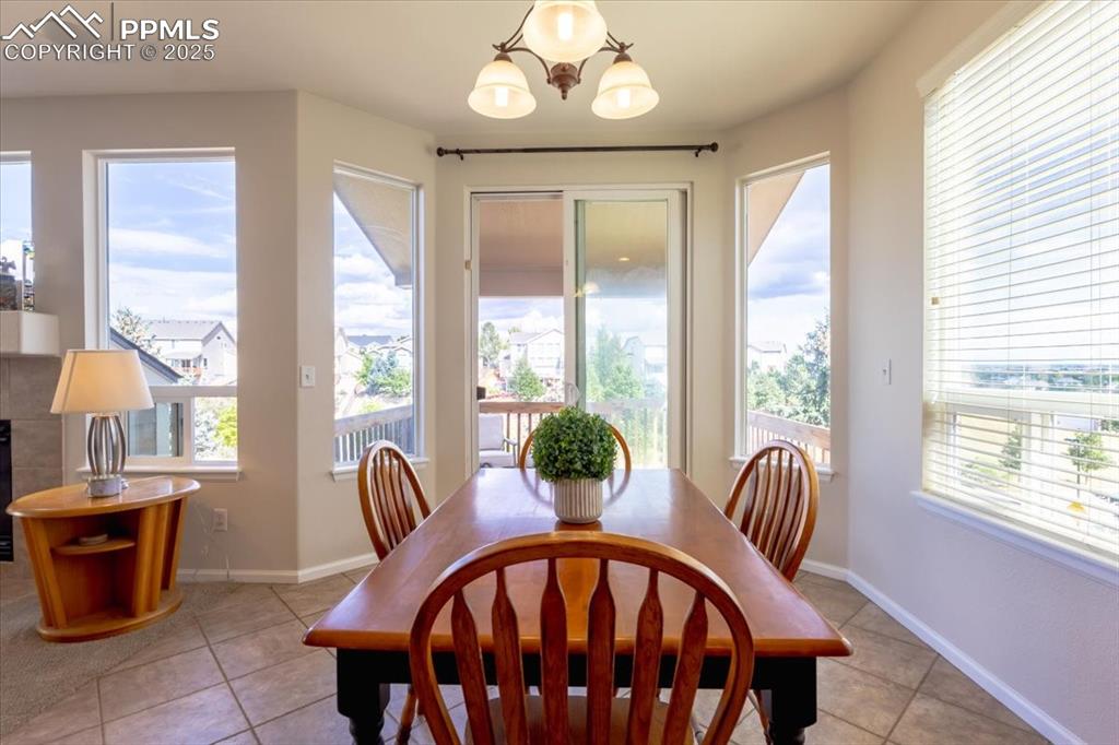 Image 11 of 30: Dining area featuring light tile patterned flooring and a chandelier