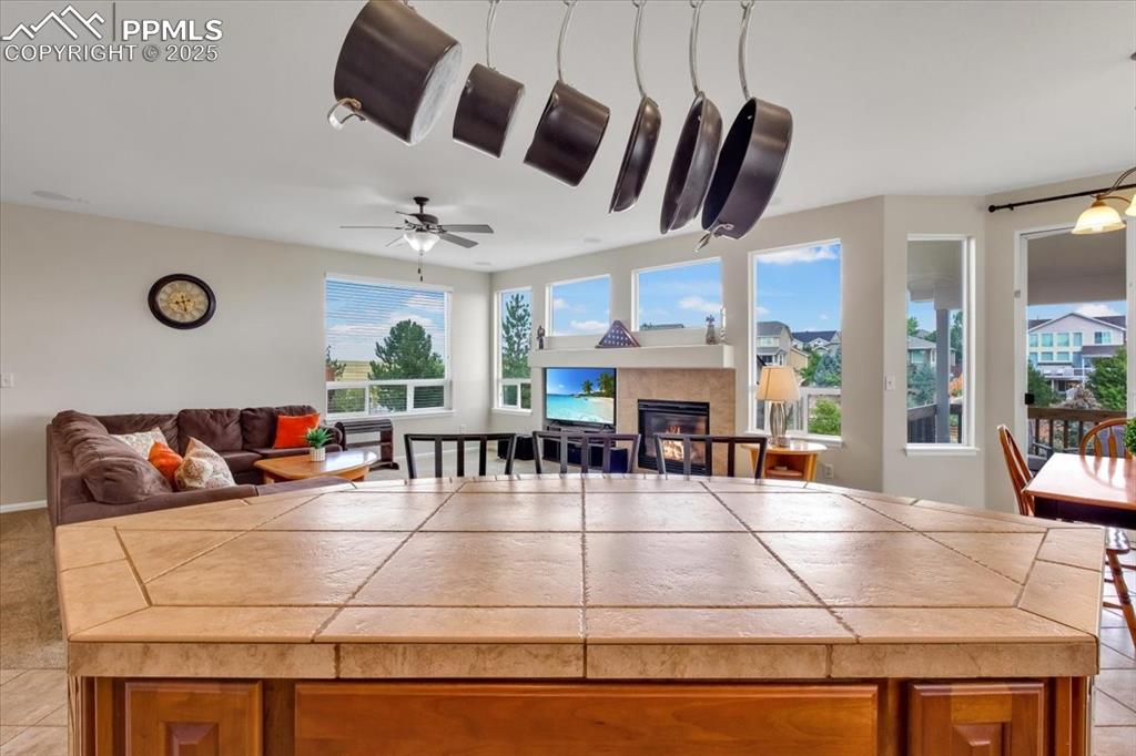 Image 13 of 30: Dining area with light tile patterned floors and a tiled fireplace