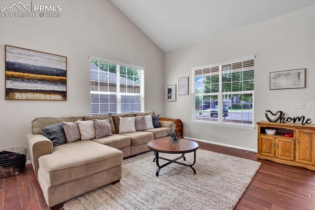 Image 8 of 30: Living area featuring dark wood-type flooring and high vaulted ceiling