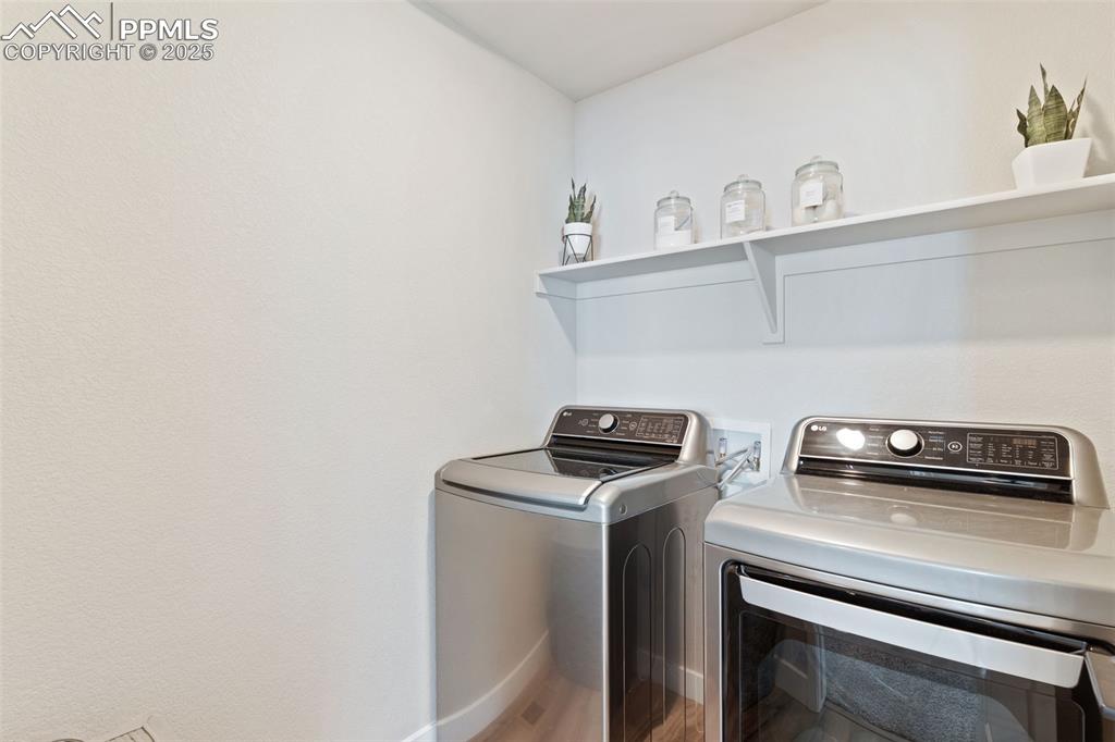 Image 16 of 26: Washroom with washing machine and dryer and wood finished floors