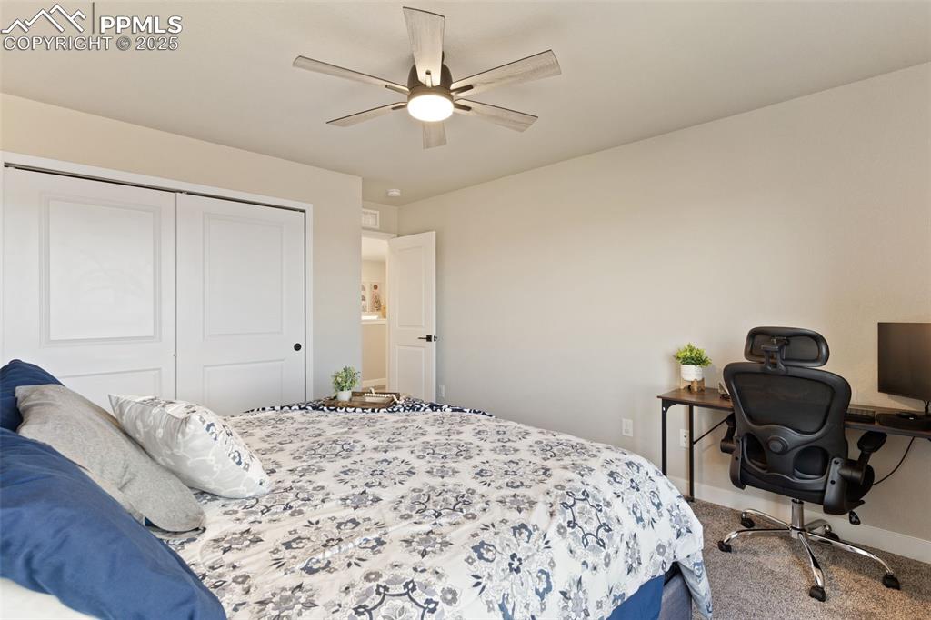 Image 18 of 26: Carpeted bedroom featuring a closet, ceiling fan, and a desk
