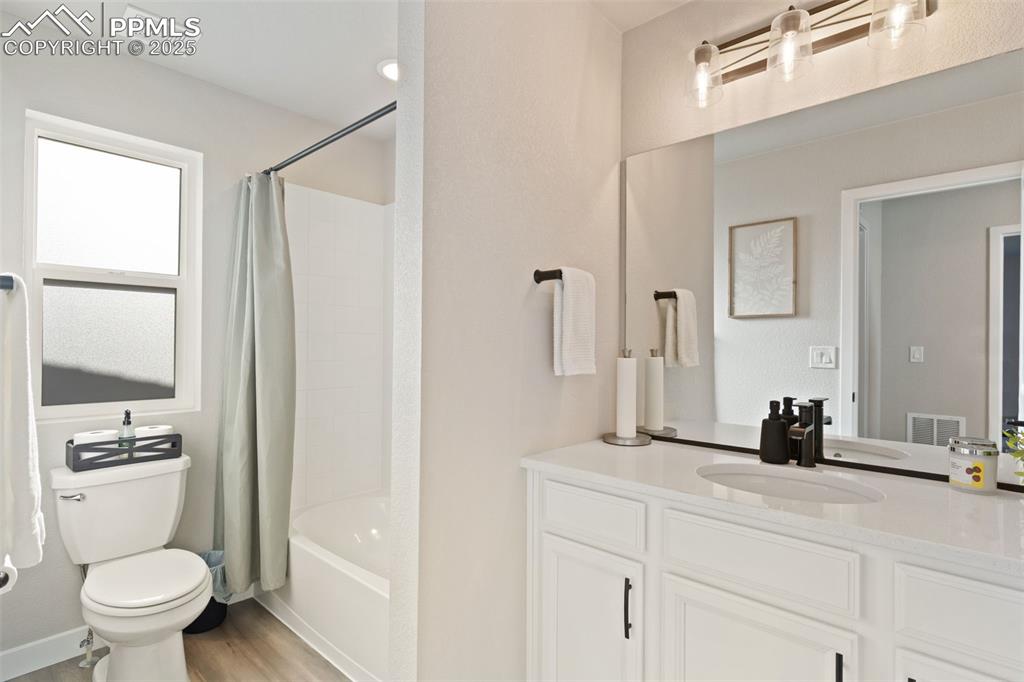 Image 19 of 26: Full bathroom featuring shower / bath combo, vanity, and light wood finishe