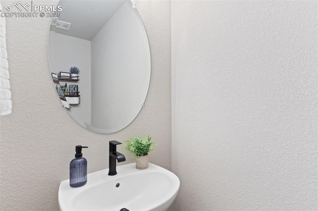 Image 23 of 26: Bathroom with a textured wall and a sink