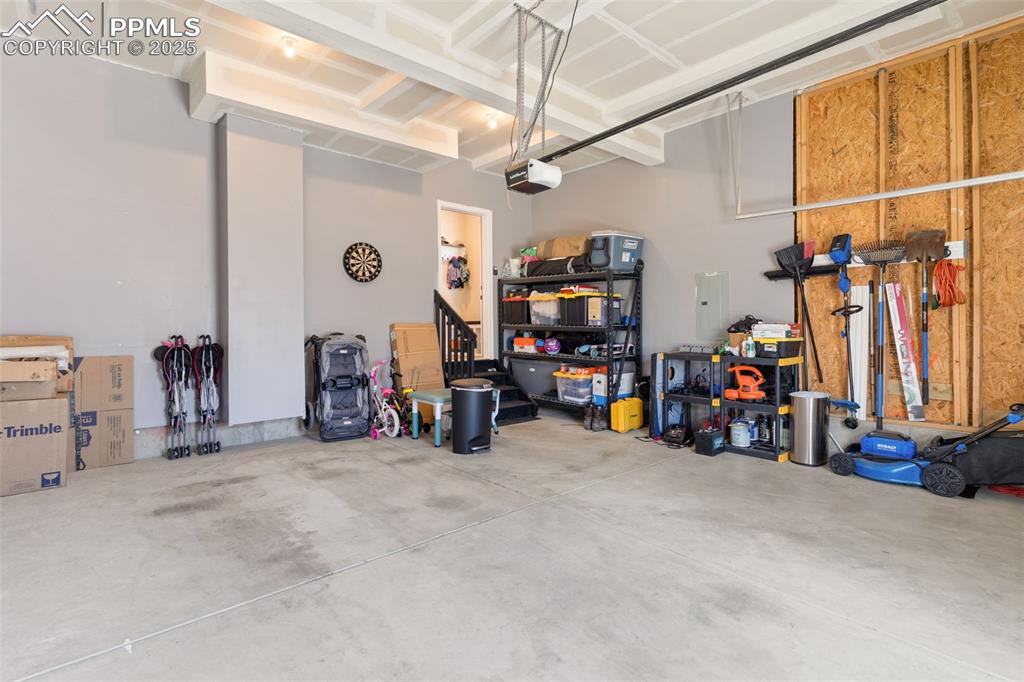 Image 24 of 26: Garage featuring electric panel and a garage door opener