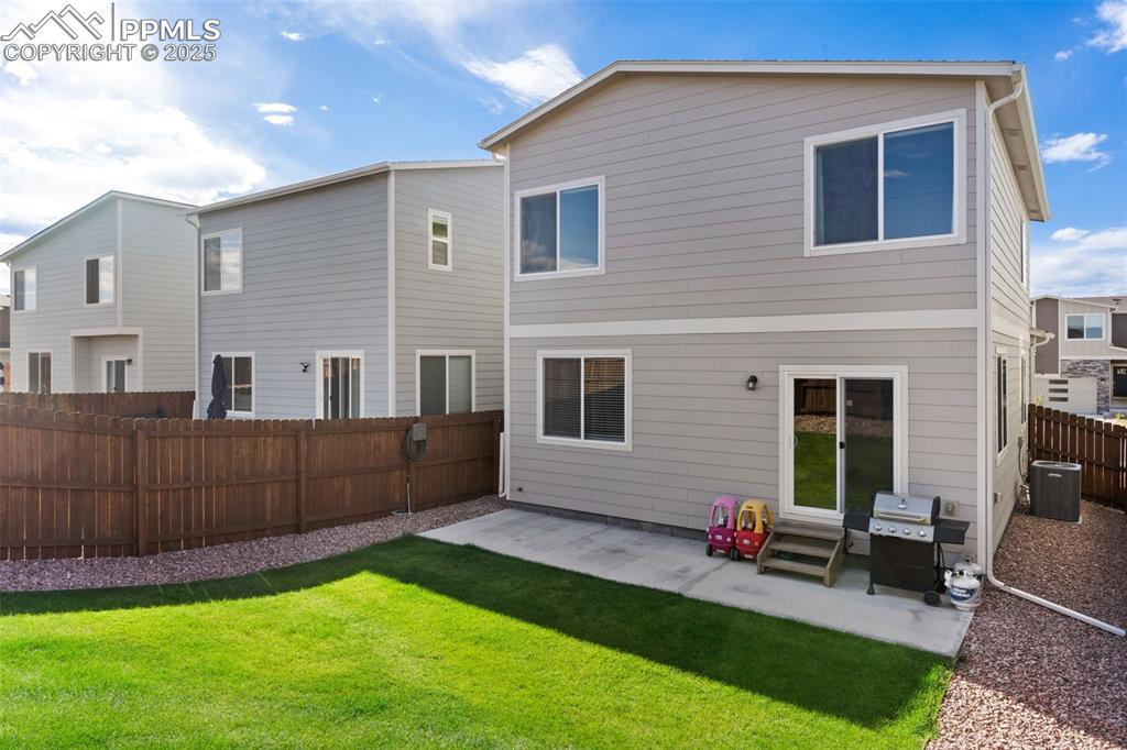 Image 26 of 26: Back of property featuring a patio, a fenced backyard, and a residential vi