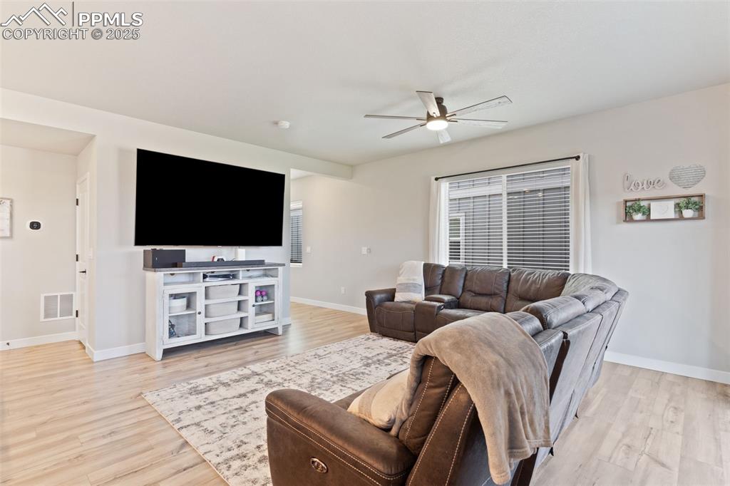 Image 5 of 26: Living area with ceiling fan and light wood-style floors