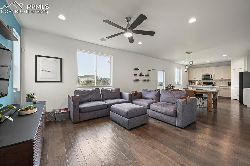 Image 4 of 50: Living room featuring recessed lighting, ceiling fan, and dark wood-style f