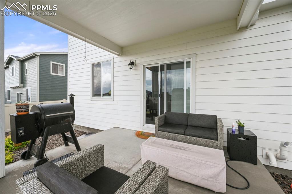 Image 41 of 50: View of covered patio with an outdoor hangout area and grilling area