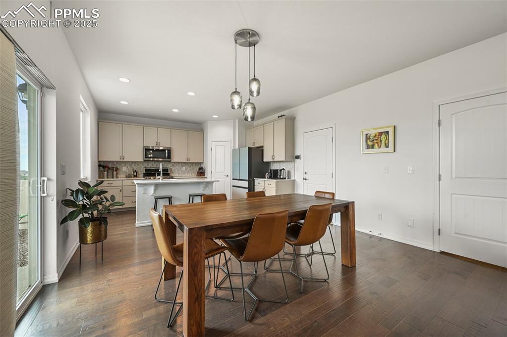 Image 9 of 50: Dining area looking toward kitchen.  Door next to cabinets leads to garage