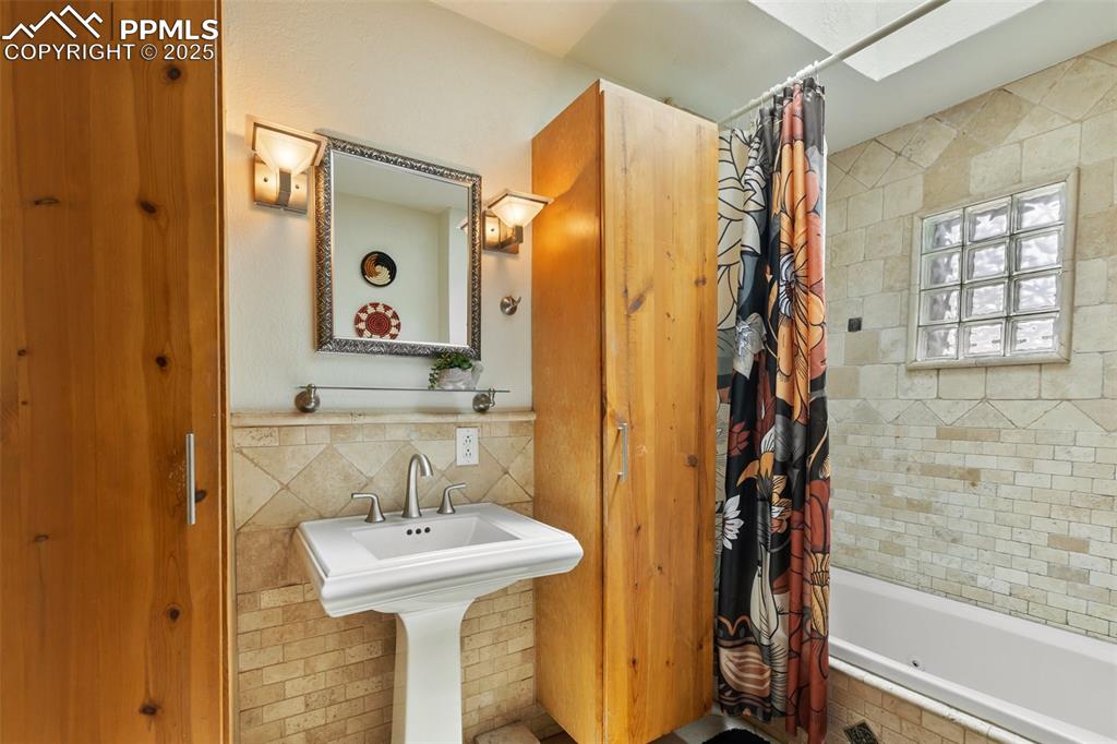 Image 12 of 43: Full bathroom on the main level off of the kitchen. 