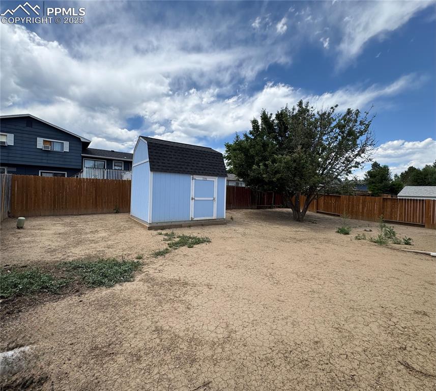 Image 17 of 17: Fenced backyard featuring a storage unit