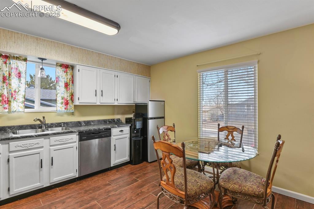 Image 6 of 17: Kitchen featuring stainless steel appliances, dark countertops, dark tile f