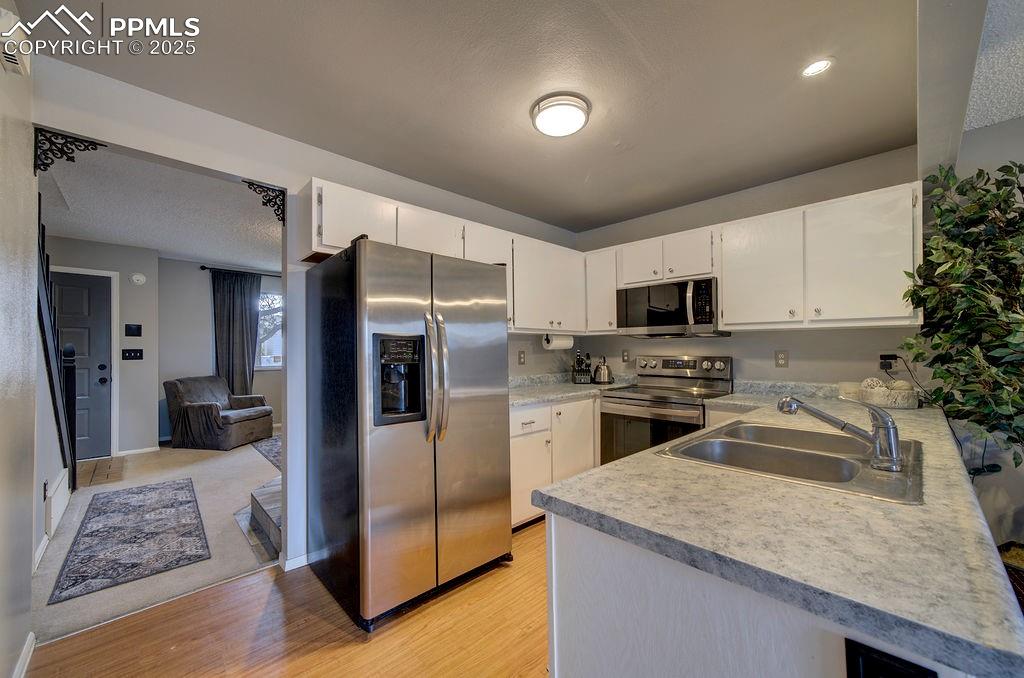 Image 11 of 48: Kitchen featuring appliances with stainless steel finishes, light counterto