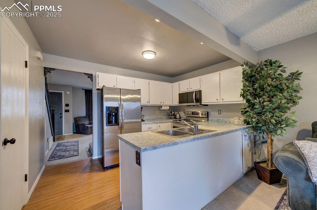 Image 19 of 48: Kitchen featuring light countertops, appliances with stainless steel finish