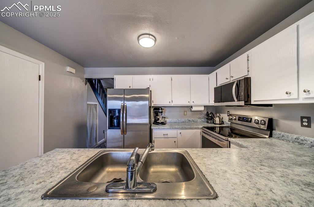 Image 20 of 48: Kitchen with light countertops, appliances with stainless steel finishes, w