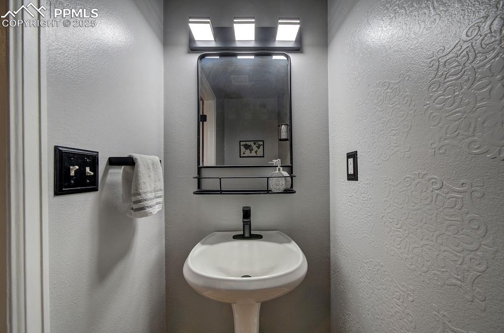 Image 24 of 48: Bathroom with a textured wall and a sink