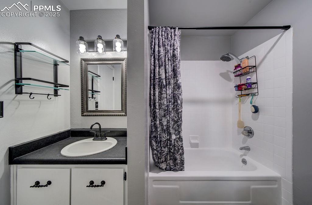 Image 34 of 48: Full bathroom with shower / tub combo, vanity, and a textured wall