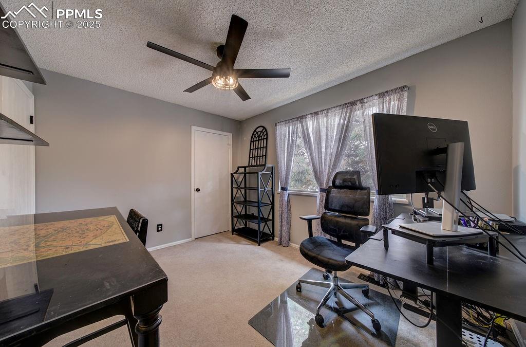 Image 38 of 48: Office featuring a textured ceiling, light colored carpet, and ceiling fan