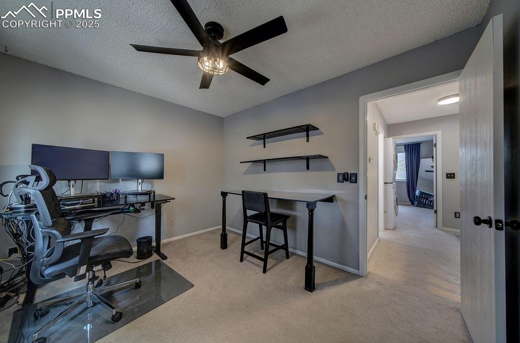 Image 39 of 48: Home office with light colored carpet, a textured ceiling, and ceiling fan
