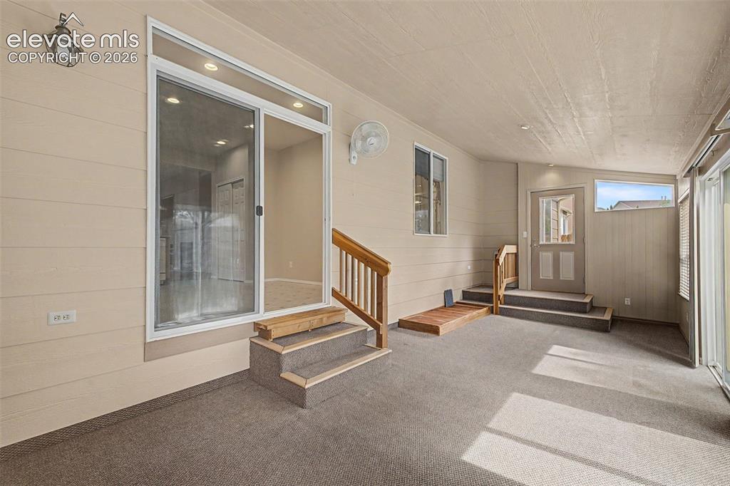 Image 21 of 49: Enclosed patio featuring durable carpet flooring and a neutral color palett