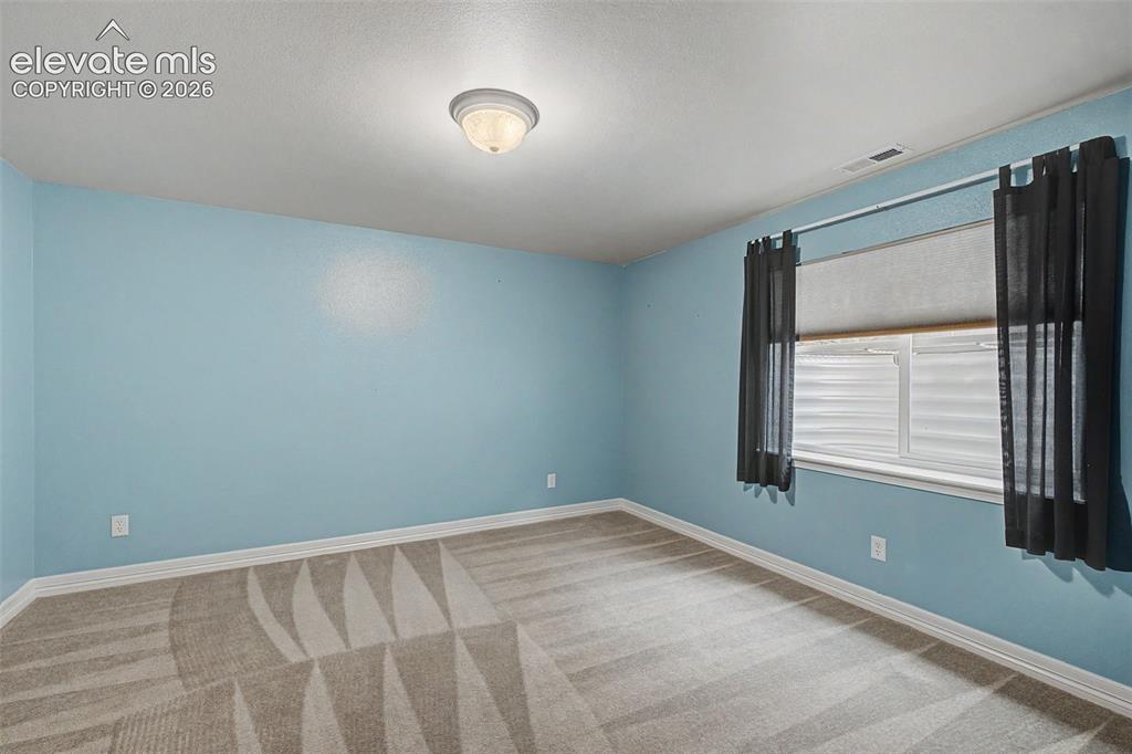 Image 30 of 49: Interior room featuring light blue walls, a white ceiling, and patterned ca