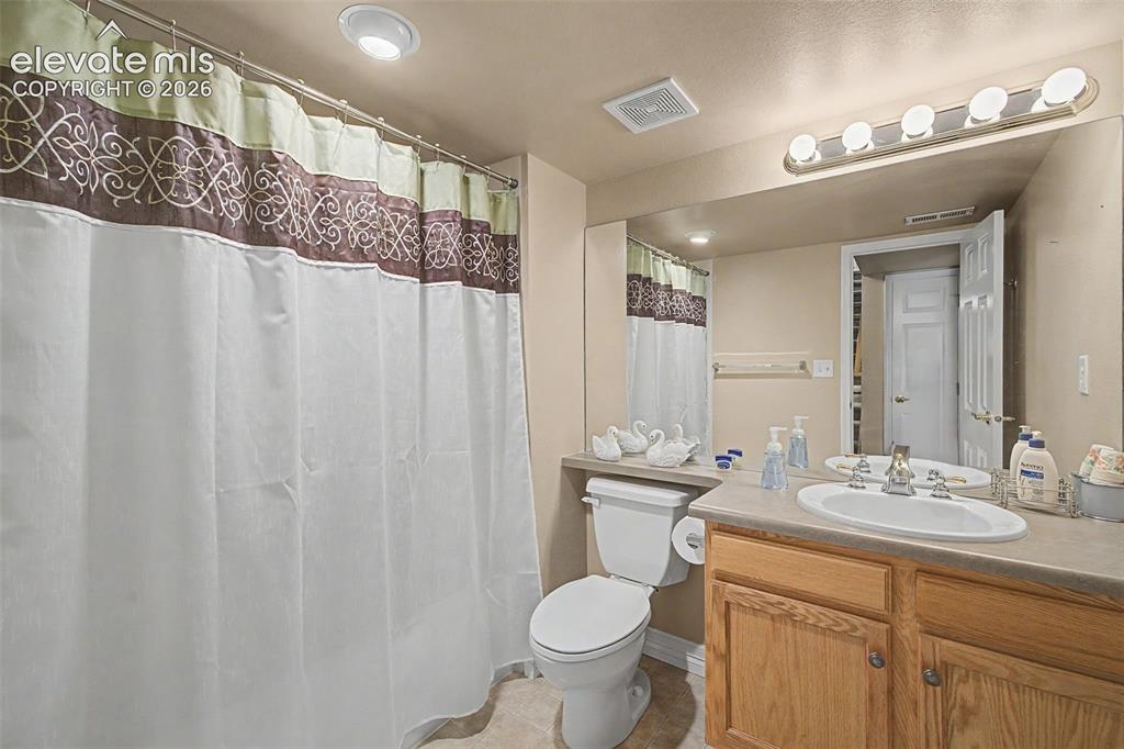 Image 32 of 49: Full bathroom featuring a single vanity with wood-finish cabinetry, an inte
