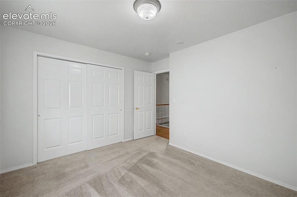 Image 34 of 49: Carpeted room featuring a ceiling-mounted light fixture, white interior wal