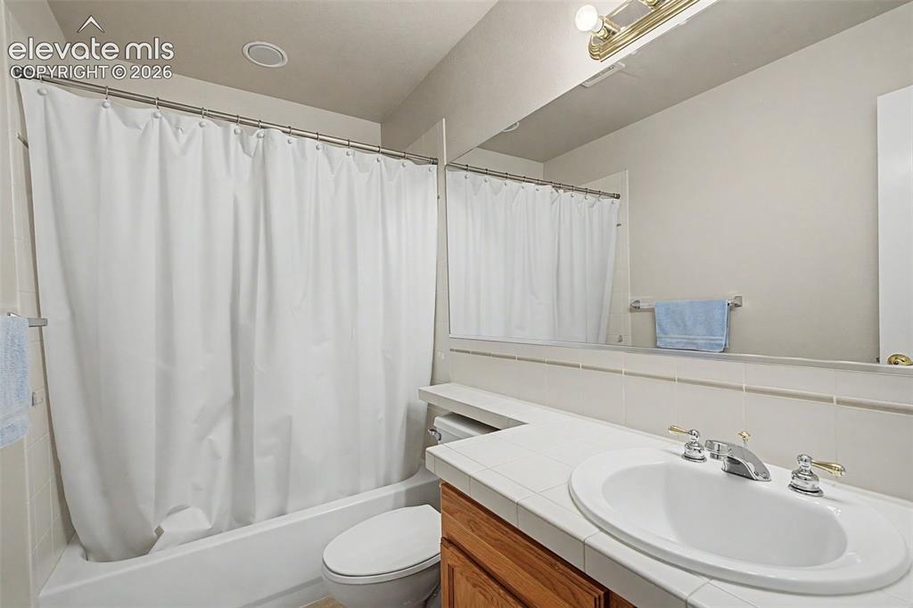Image 35 of 49: Bathroom featuring a white drop-in sink with a chrome two-handle faucet, a