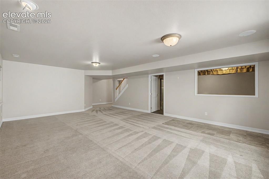 Image 44 of 49: Spacious room with light-toned carpeting and neutral wall paint