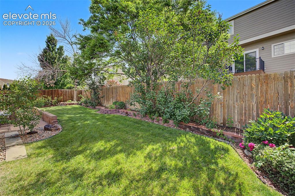Image 47 of 49: Expansive backyard featuring a manicured lawn, established perimeter landsc