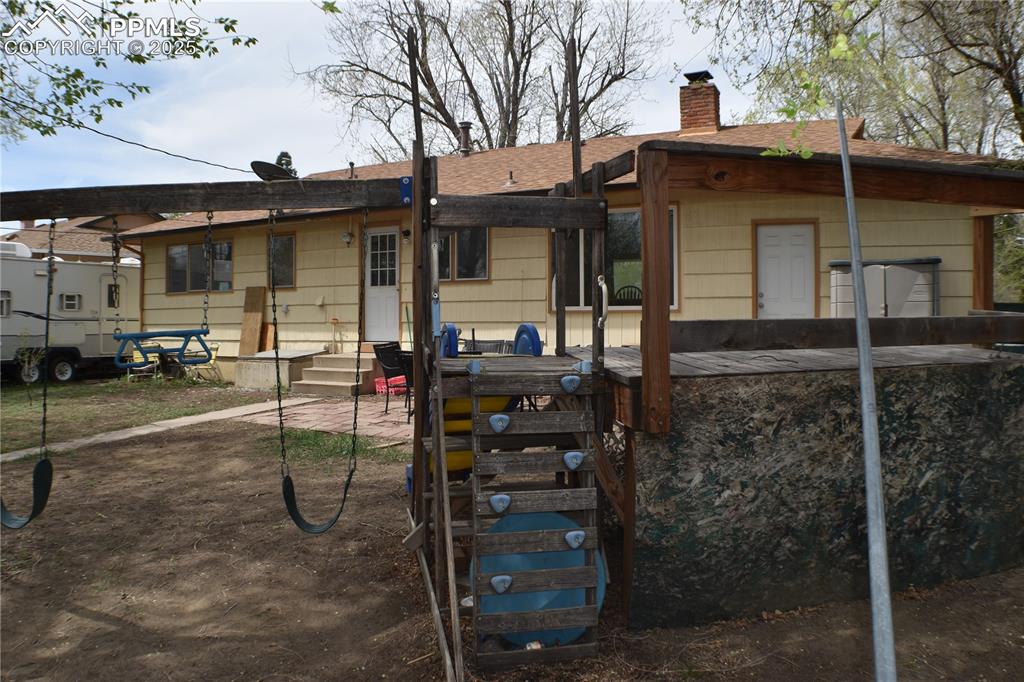 Image 27 of 31: Back of property featuring a chimney, roof with shingles, a patio area, and
