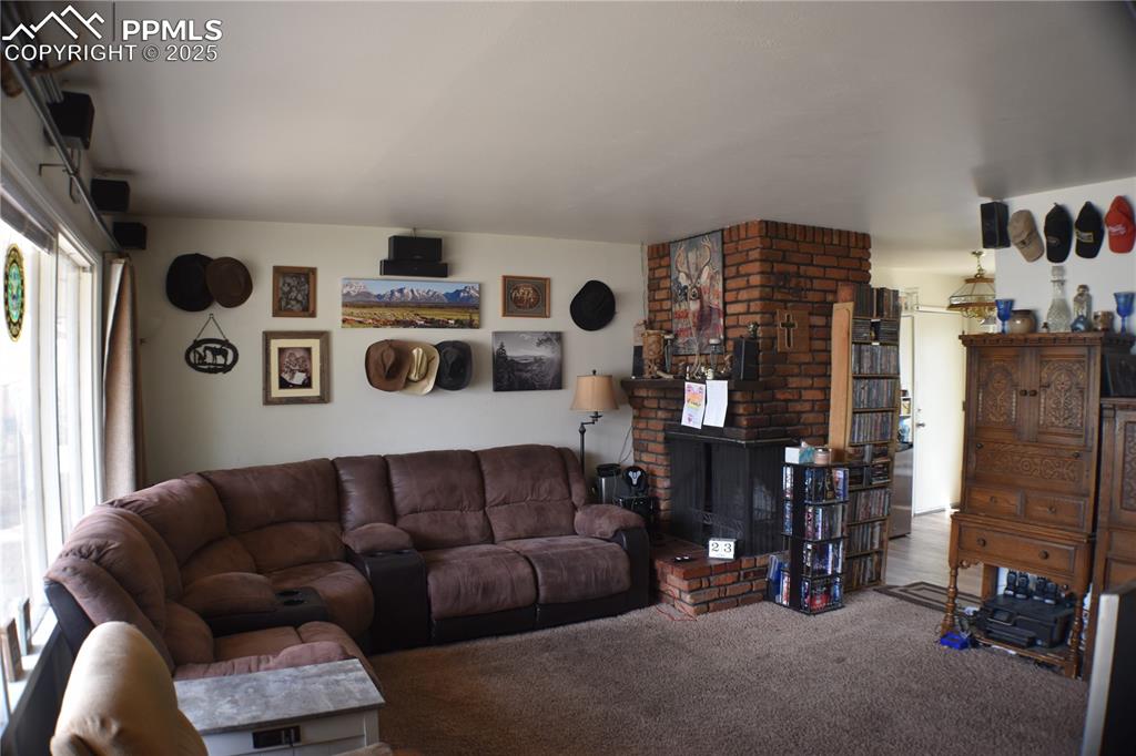Image 3 of 31: Carpeted living area featuring a fireplace