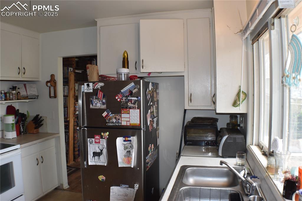 Image 5 of 31: Kitchen featuring freestanding refrigerator, electric range, a sink, and a 