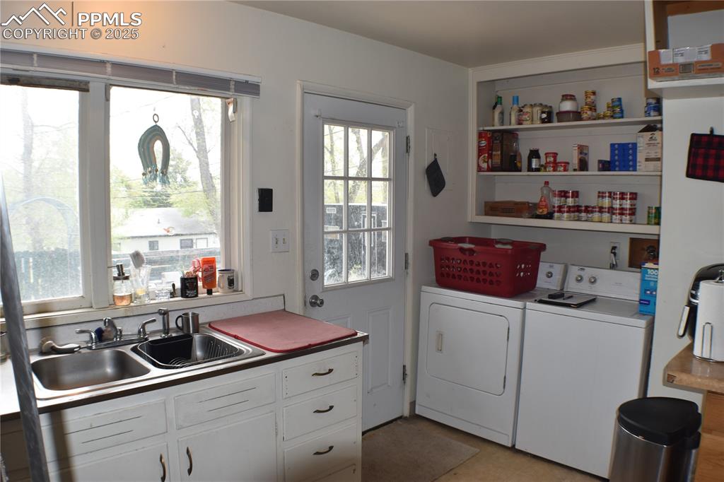 Image 8 of 31: Laundry room featuring washing machine and dryer, a sink, and laundry area