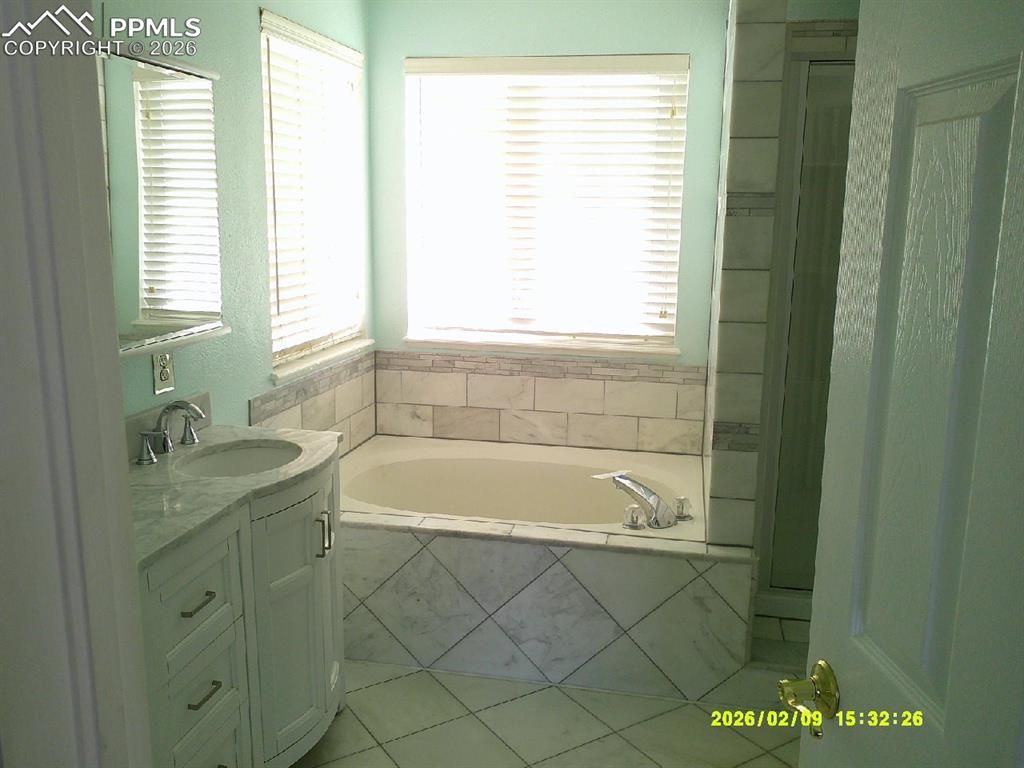 Image 10 of 21: Full bath featuring vanity and a bath