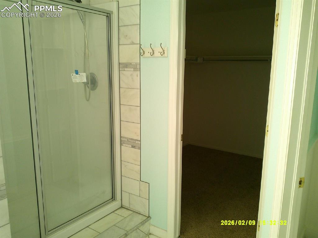 Image 11 of 21: Full bath featuring a stall shower and a spacious closet