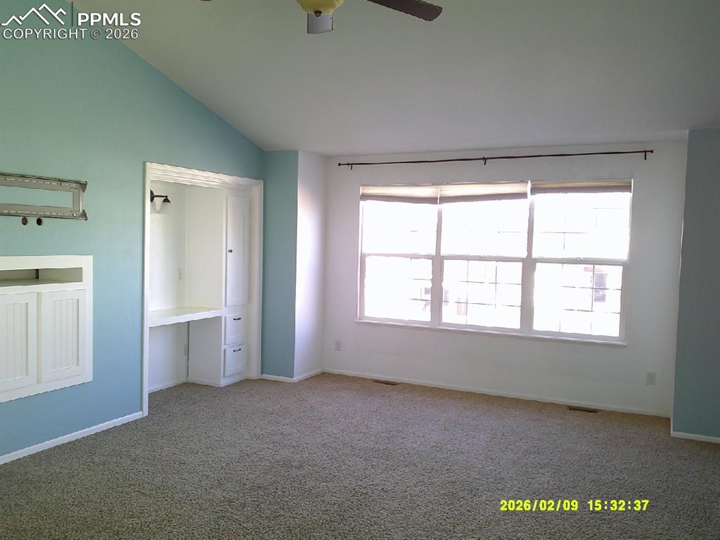 Image 12 of 21: Unfurnished bedroom featuring carpet flooring, a ceiling fan, lofted ceilin
