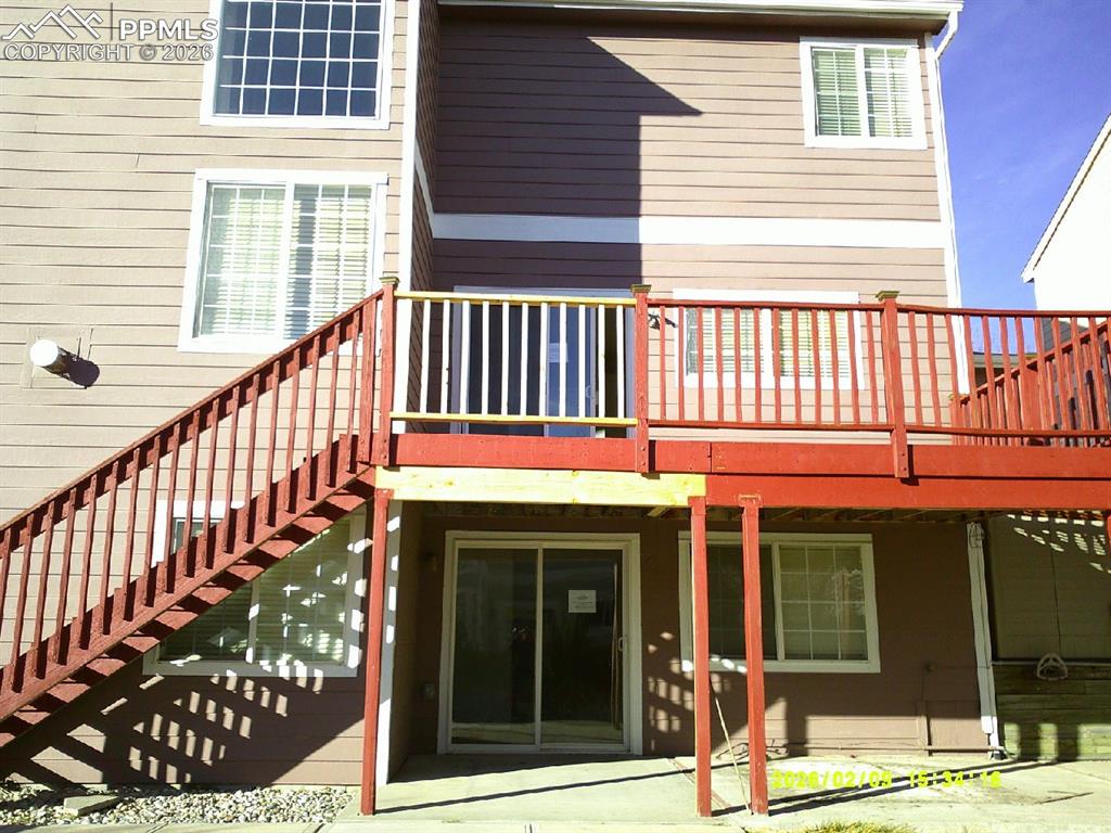 Image 19 of 21: Rear view of house featuring a wooden deck and a patio area