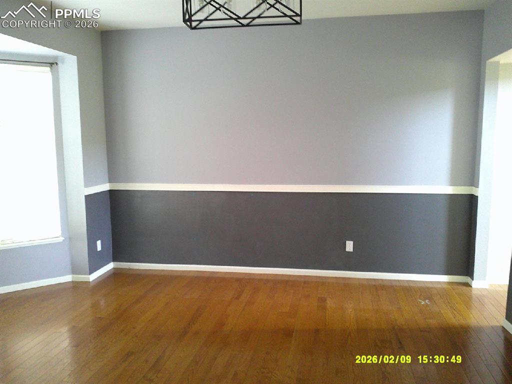 Image 3 of 21: Unfurnished dining area featuring hardwood / wood-style floors and baseboar