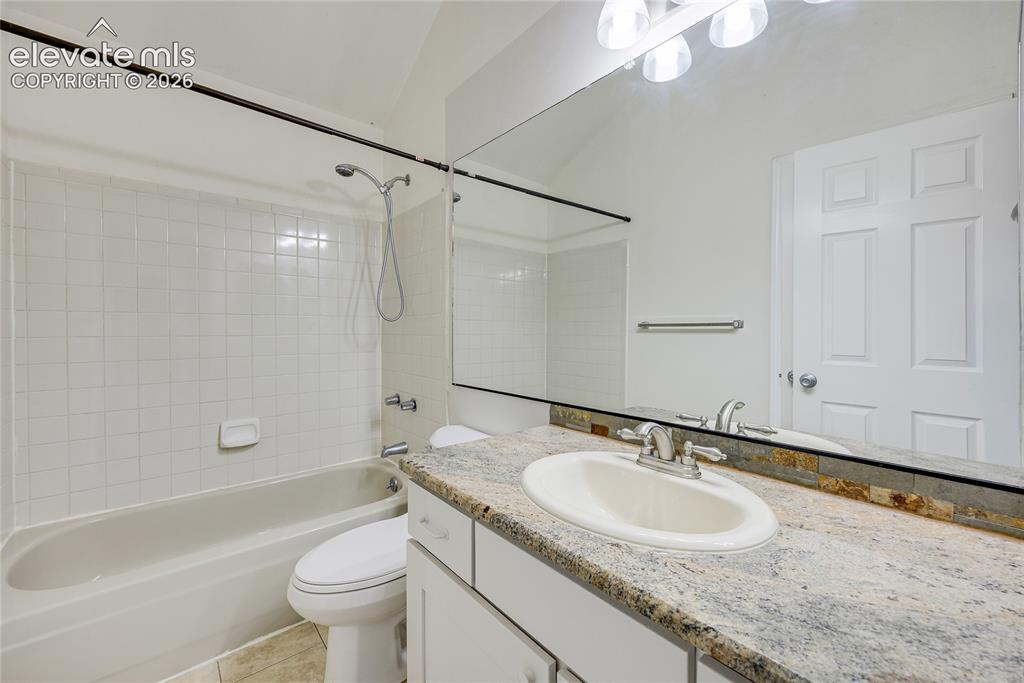 Image 18 of 27: White rectangular tile shower surround, shower/tub combination, white vanit
