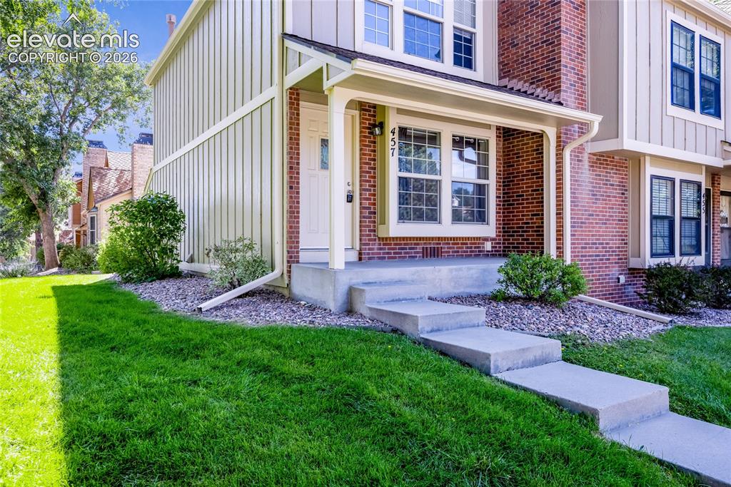 Image 3 of 27: Brick and vertical siding exterior with a covered entry