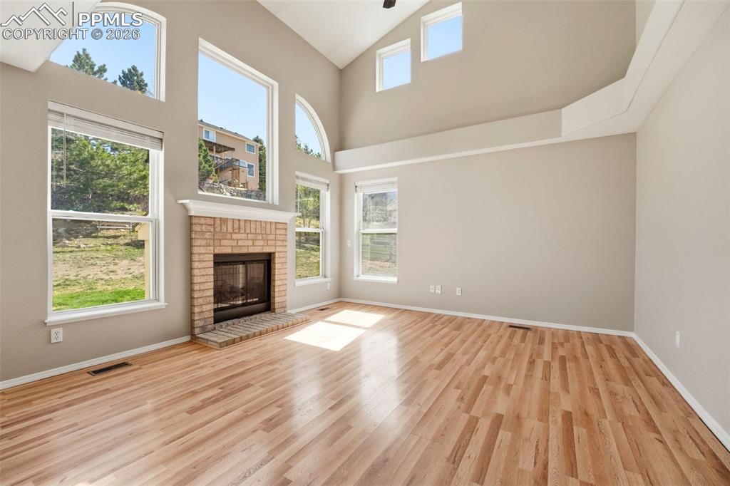 Image 12 of 49: 2-story ceilings with walls of windows and gas fireplace