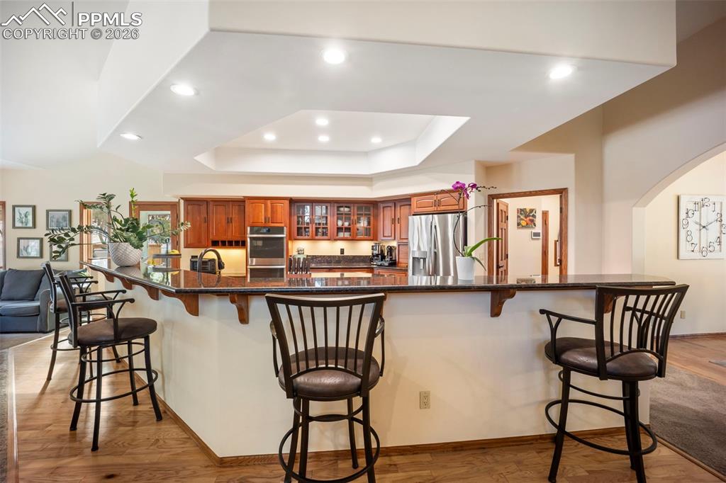 Image 14 of 48: Kitchen featuring a breakfast bar area, light wood-style flooring, stainles
