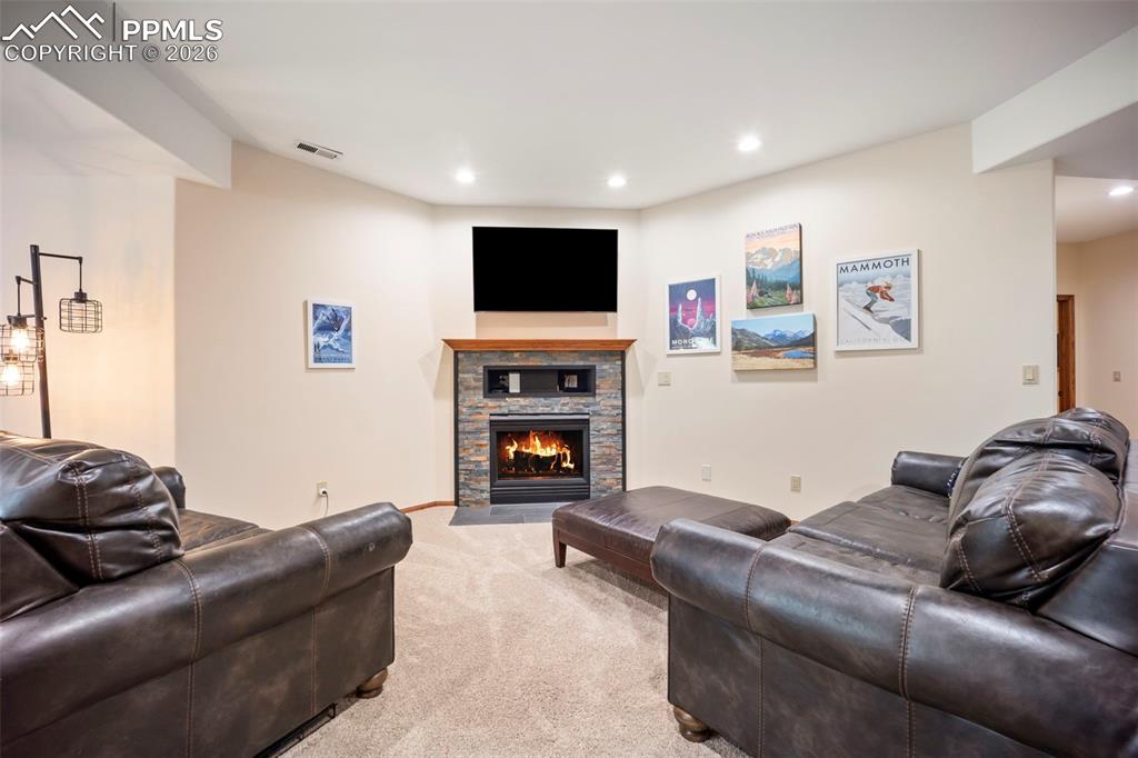 Image 26 of 48: Living room featuring light carpet, a gas fireplace, and recessed lighting