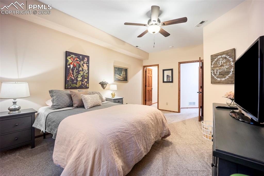 Image 33 of 48: Bedroom with light carpet and a ceiling fan