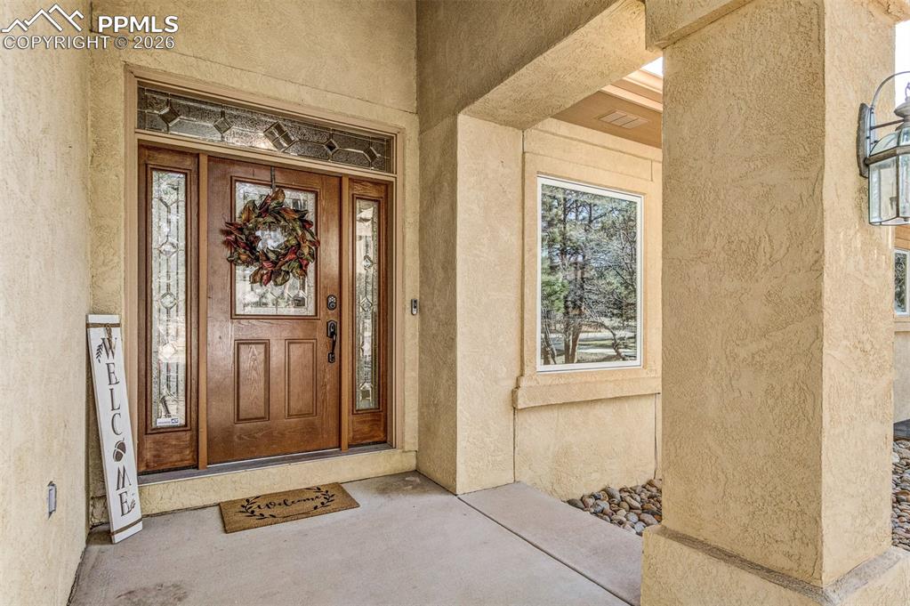 Image 4 of 48: View of exterior entry featuring stucco siding and covered porch