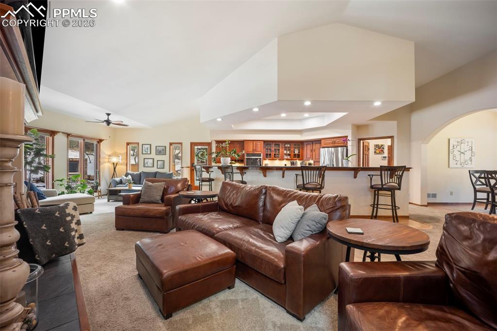 Image 7 of 48: Carpeted living room with recessed lighting, ceiling fan, vaulted ceiling